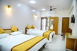 a hotel room with two beds and a television at Aldur Residency in Aldūr +46 photos