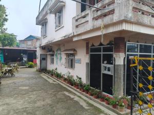a building with potted plants in front of it at Ilam Pahuna Ghar in Ilām