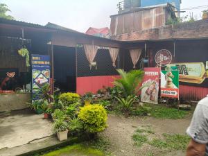 a building with plants and signs in front of it at Ilam Pahuna Ghar in Ilām +1 photo