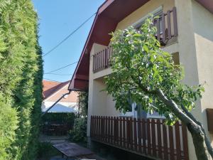 a house with a balcony and a tree at Gabriella Ház in Szólád