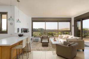 a kitchen and living room with a couch and a table at Mamad Comfort & Terrace In Ramat Aviv By Feelhome in Tel Aviv