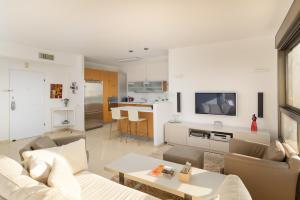 a living room with a couch and a table at Mamad Comfort & Terrace In Ramat Aviv By Feelhome in Tel Aviv