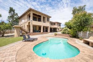a home with a swimming pool in front of a house at Siyajabula Guesthouse in Howick