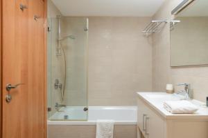 a bathroom with a tub and a sink and a shower at Mamad Comfort & Terrace In Ramat Aviv By Feelhome in Tel Aviv +21 photos
