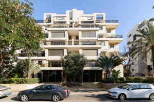 two cars parked in front of a building at Mamad Comfort & Terrace In Ramat Aviv By Feelhome in Tel Aviv
