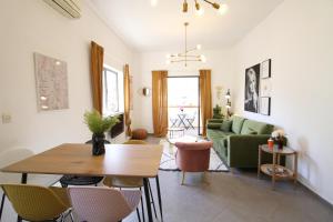 a living room with a green couch and a table at Design & Balcony In City Center By Feelhome in Tel Aviv