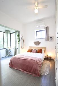 a bedroom with a large bed in a room with windows at Design & Balcony In City Center By Feelhome in Tel Aviv +12 photos