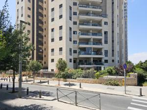 a street with a tall building in the background at Mamad Family Friendly New Condo By Feelhome in Yerushalayim