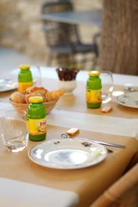 a table with a plate of bread and bottles of mustard at HÖTEL U SANTA MARIA in Olmeto