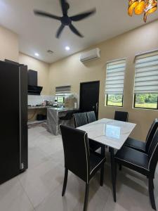 a dining room with a ceiling fan and a table and chairs at Homestay ZASS in Arau