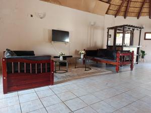 a living room with two couches and a flat screen tv at The Huts in Vila Praia Do Bilene