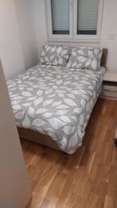 a bed in a bedroom with a wooden floor at Apartman Stan Laktasi in Laktaši