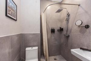 a bathroom with a shower with a toilet and a sink at TAU 28 Hotel in Almaty +42 photos
