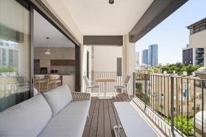 a living room with a couch on a balcony at Mamad New With Terrace Next To Park By Feelhome in Tel Aviv