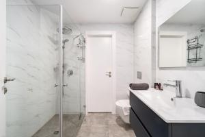 a bathroom with a shower and a sink and a toilet at Mamad New With Terrace Next To Park By Feelhome in Tel Aviv +26 photos