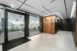 an office with a hallway with a door and windows at Mamad New With Terrace Next To Park By Feelhome in Tel Aviv