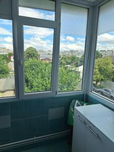 a kitchen with three windows with a view at Vibe Apartament 17 in Galaţi
