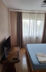 a bedroom with a bed and a desk with a computer at Vibe Apartament 17 in Galaţi