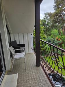 a balcony with a white chair and a table at Molas svečių namai in Klaipėda