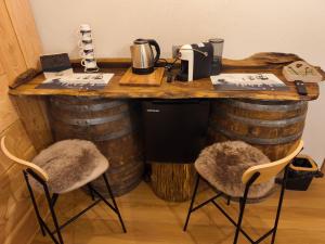 a bar made out of wine barrels with two chairs at Lu Cheur ad Zona Verde in Limone Piemonte
