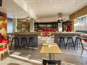 a restaurant with tables and chairs and a bar at Ibis Queretaro in Querétaro