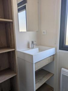 a bathroom with a white sink and a mirror at Camping 2 étoiles - Piscine - ccbgcid in Belloc