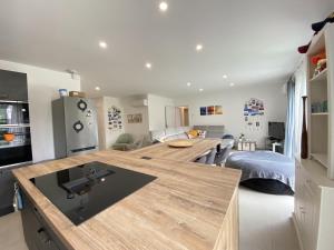 a kitchen with a large wooden counter in a room at La Maison Moderne - 6 pers - SPA - Piscine in Saint-Sauveur-dʼAunis