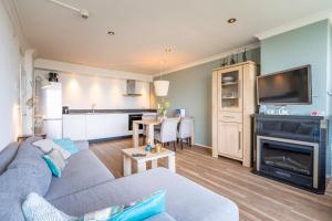 a living room with a couch and a fireplace at Appartementencomplex Juliana 164 in De Koog