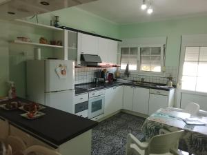 a kitchen with a white refrigerator and a table at Villa Mastiha , Komi Beach in Kómi