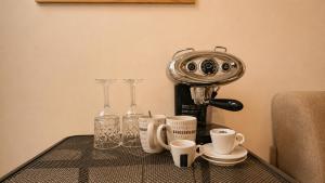 a table with cups and a coffee maker on it at Aime's House in Sliema