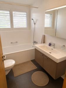 a bathroom with a tub and a sink and a toilet at Skender's Apartment in Interlaken