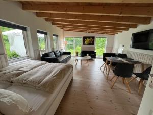 a bedroom with a large bed and a living room at foresthaus in Glücksburg