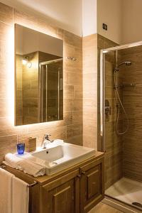 bagno con lavandino e doccia con specchio di Residence Hotel K2 a Foppolo