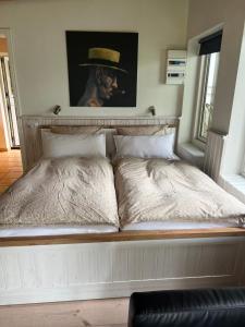 a bed with a painting of a man with a hat at foresthaus in Glücksburg