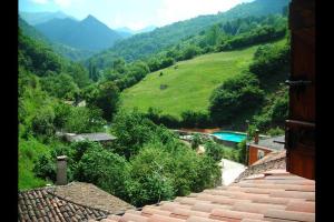 a view of a valley with a house and a mountain at La Cuadrina de Anton in Pajares