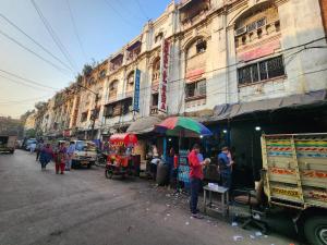 a person standing under an umbrella on a street at Hotel Al Sana in Kolkata