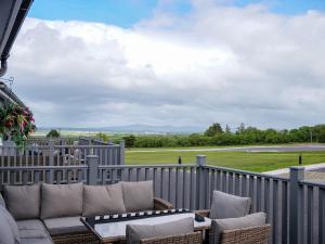 a patio with a couch and chairs on a fence at Mountain View Cottages in Tralee