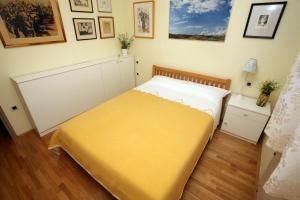 ein Schlafzimmer mit einem Bett mit einer gelben Decke in der Unterkunft Apartman Halugica in Lovran