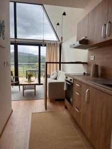 a kitchen and living room with a large window at Áčko in Oščadnica