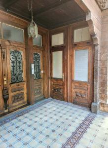 an empty room with wooden doors and a tile floor at Villa Alti Ländte in Oberhofen am Thunersee