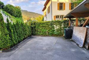 a driveway in front of a house with a hedge at Villa Alti Ländte in Oberhofen am Thunersee +31 photos
