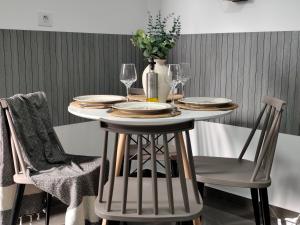 a dining room table with plates and wine glasses at Argiros Apartments in Kefalos +30 photos