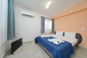 a bedroom with a bed with towels on it at Studios Tasos Bi 2 in Chrysi Ammoudia