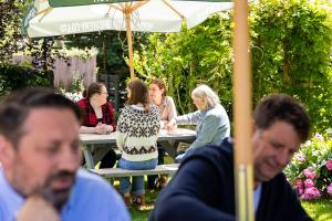 a group of people sitting at a picnic table at The George Inn in Lower Brailes