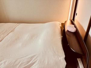a bedroom with a white bed with a wooden head board at Ajisai Coral Princess Villa in Shirahama