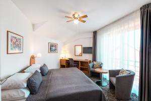 ein Schlafzimmer mit Bett und ein Wohnzimmer in der Unterkunft Hotel Troja in Prag