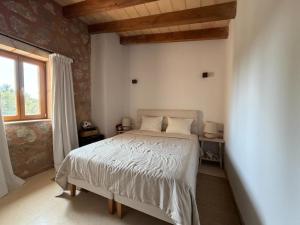 a bedroom with a white bed and a window at Finca Latenéa in Islas Baleares +2 photos