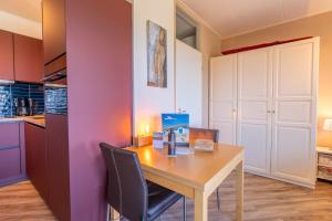 a dining room table with chairs and a candle on it at Appartementencomplex Juliana 158 in De Koog