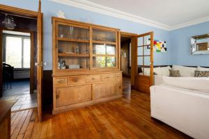 a living room with a wooden hutch and a bed at L'Oasis Familiale Arborée - Welkeys in Vincennes