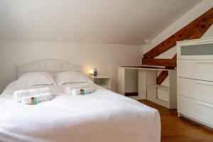 a bedroom with a white bed with towels on it at L'Oasis Familiale Arborée - Welkeys in Vincennes +16 photos